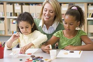 Two students in art class with teacher