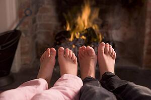 Children's feet warming at a fireplace
