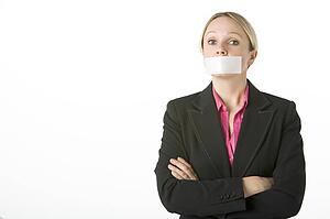 Businesswoman With Her Arms Folded And Mouth Taped Shut