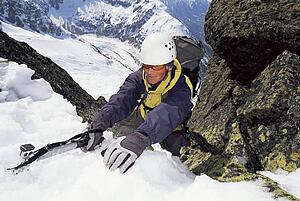 Mountain climber coming up snowy mountain