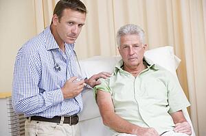 Doctor giving man needle in exam room