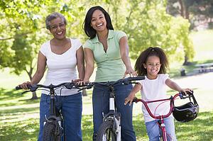 Grandmother with adult daughter and grandchild riding bikes