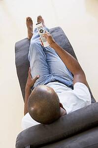 Man sitting in chair using remote control