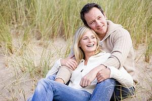 Couple sitting on beach smiling