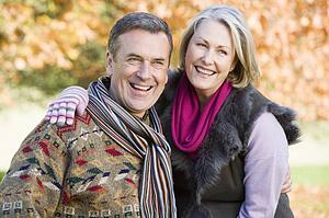 Couple outdoors embracing and smiling (selective focus)