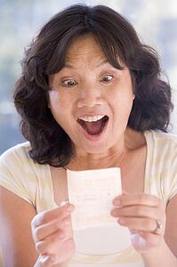 Woman with winning lottery ticket excited and smiling
