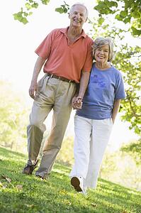 Senior couple walking in park together