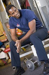 Fireman sitting on bench in fire station locker room