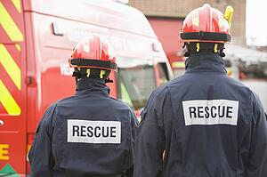 Two rescue workers standing near rescue vehicle