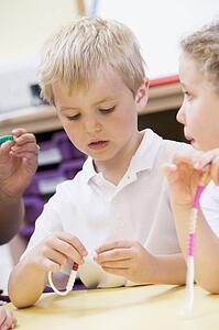 Students in math class using counting beads (selective focus)
