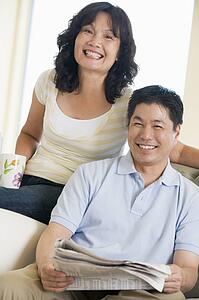 Couple relaxing with a newspaper and smiling