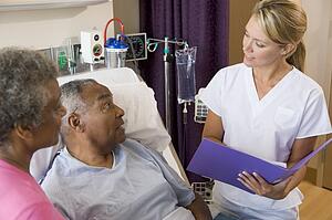 Doctor Talking To Senior Couples, Making Notes