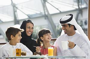 Family at restaurant eating dessert and smiling (selective focus)