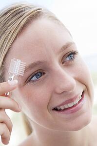 Woman with eyebrow brush smiling