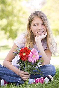 Young girl holding flowers and smiling
