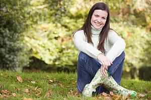 Woman sitting outdoors smiling (selective focus)