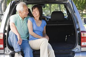 Couple sitting in back of van smiling