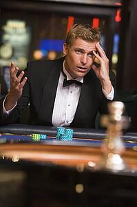 Man in casino playing roulette and losing (selective focus)