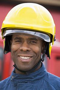 Fireman standing by fire engine wearing helmet