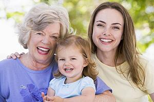 Grandmother with adult daughter and grandchild in park