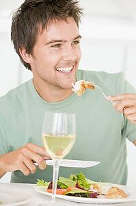 Young Man Enjoying meal, mealtime With A Glass Of Wine