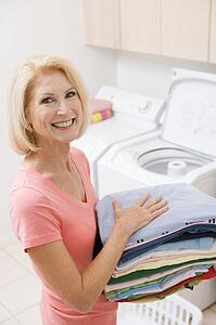 Woman Carrying Folded Up Laundry
