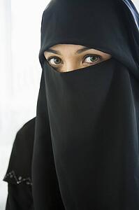 Woman wearing black veil indoors (high key)