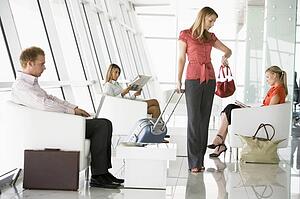 Female airline passenger waiting with other passengers in departure gate