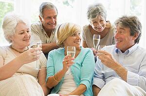 Five friends in living room drinking champagne and smiling
