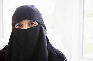 Woman wearing black veil indoors (high key)