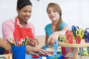 Teacher and student in art class with supplies in foreground (selective focus)