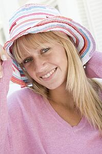 Blonde woman in a pink sweater posing outdoors