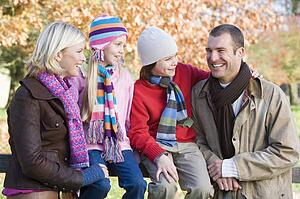 Family outdoors in park smiling (selective focus)