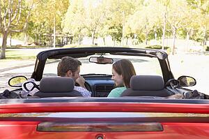 Couple in convertible car smiling