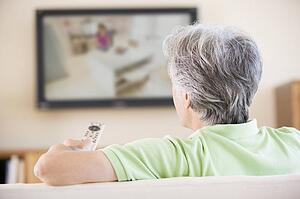 Man watching television using remote control