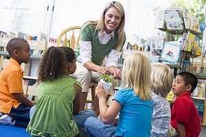 Teacher in class showing students bamboo plant
