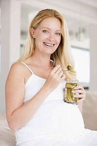 Pregnant woman with pickles smiling