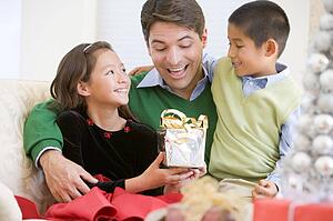 Father Being Given A Christmas Present By His Daughter And Son
