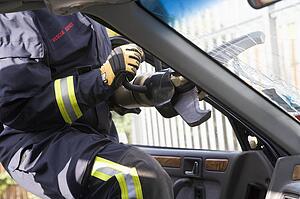 Firefighter cutting out a windshield after an accident
