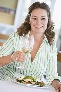 Woman Enjoying meal, mealtime With A Glass Of Wine