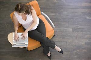 Businesswoman sitting indoors with laptop