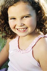 Young girl sitting outdoors smiling