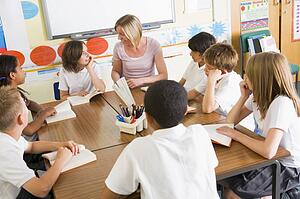 Students in class reading books with teacher