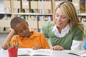 Student in class reading with teacher