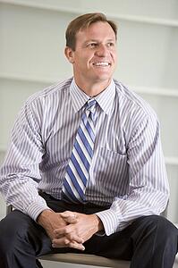 Businessman sitting indoors smiling