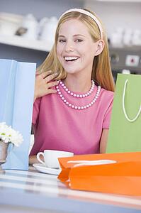Young woman sitting at a table taking a break from shopping