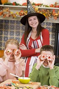 Mother and two children at Halloween playing with treats and smiling