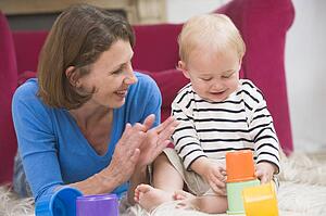Mother in living room playing with baby smiling