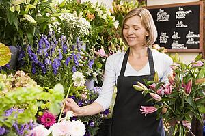 Woman working at flower shop smiling