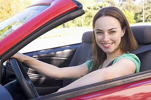 Woman in convertible car smiling